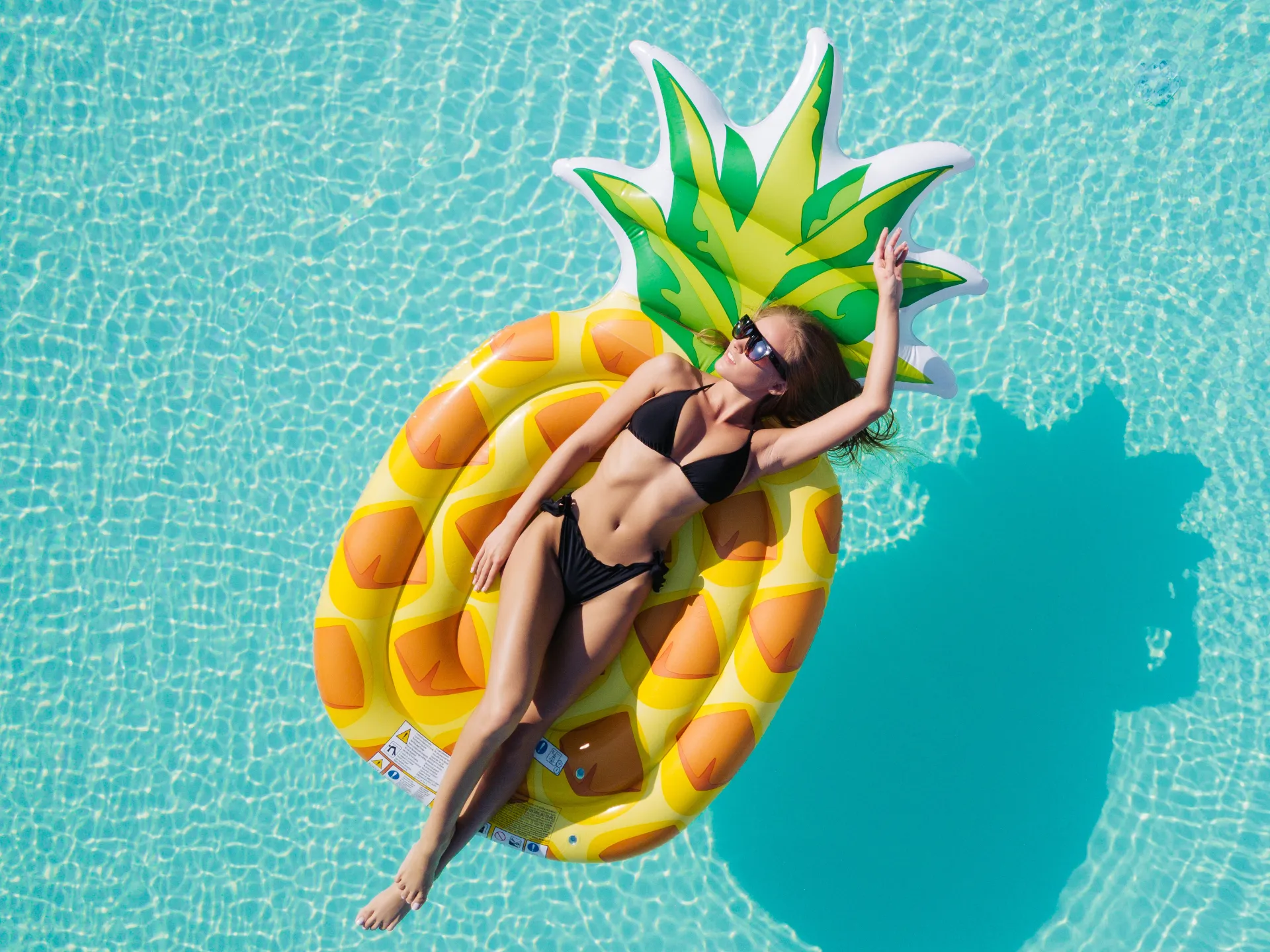 Frau entspannt auf einer Luftmatratze in einem Pool