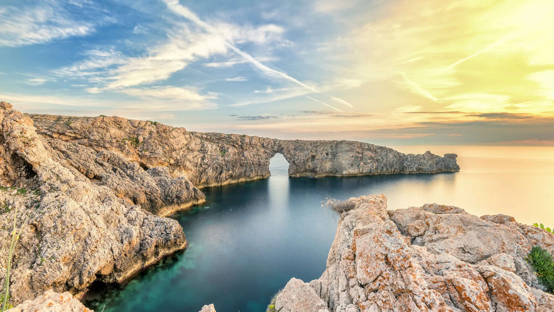 Felsbogen an der Küste von Menorca mit Blick auf das Meer.