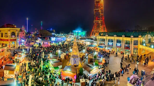 Nächtliche Gesamtansicht des Wintermarkts am Riesenradplatz mit beleuchteten Ständen
